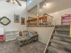 Stairway featuring carpet, ceiling fan, and vaulted ceiling