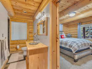 Bedroom with wooden ceiling and log walls