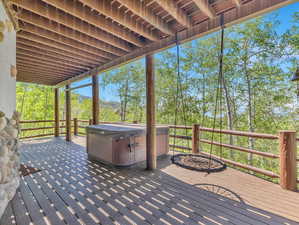 Wooden terrace featuring a hot tub