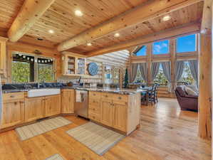 Kitchen featuring light hardwood / wood-style floors, sink, kitchen peninsula, and rustic walls