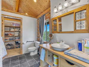 Bathroom featuring vanity, toilet, and wood ceiling