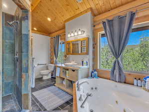 Bathroom with a shower with shower door, tile patterned floors, vanity, and toilet