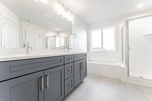 Bathroom with a bath, visible vents, double vanity, a sink, and a stall shower