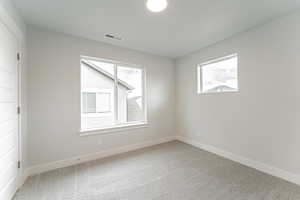 Spare room featuring baseboards, carpet flooring, and visible vents