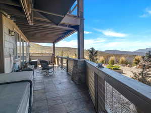 View of patio with a mountain view and a balcony