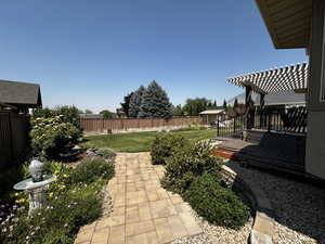 View of yard featuring a wooden deck and a pergola