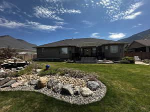 Back of property featuring a pergola and a lawn