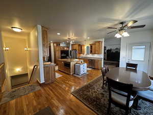 Dining space with ceiling fan, wood-type flooring, and sink