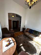 Living room with hardwood / wood-style floors and an inviting chandelier