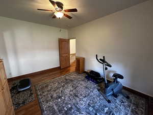 Workout room with wood-type flooring and ceiling fan