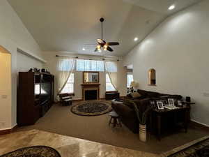 Tiled living room featuring high vaulted ceiling and ceiling fan