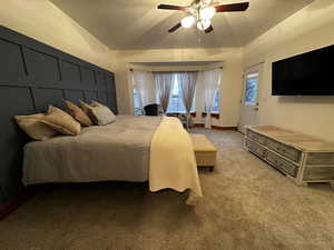 Bedroom with vaulted ceiling, light carpet, and ceiling fan