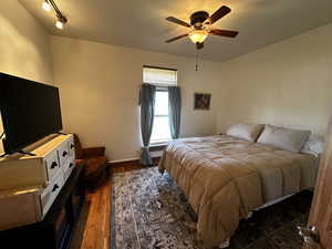 Bedroom with ceiling fan and dark hardwood / wood-style floors