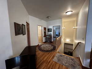 Hallway with hardwood / wood-style floors