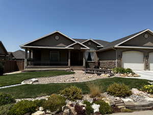 View of front of home with a porch, a garage, and a front lawn