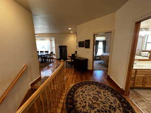 Corridor featuring dark wood-type flooring, plenty of natural light, an inviting chandelier, and sink