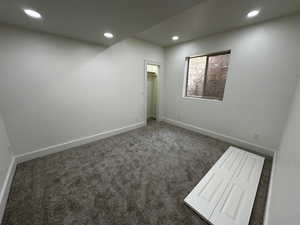 Spare room with dark colored carpet