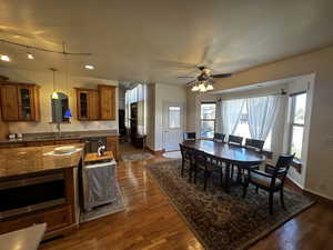 Dining area with sink, ceiling fan, and dark hardwood / wood-style floors