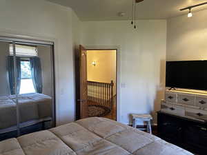 Bedroom featuring a closet, hardwood / wood-style floors, and track lighting