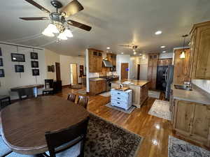 Dining room with ceiling fan, dark hardwood / wood-style floors, and sink