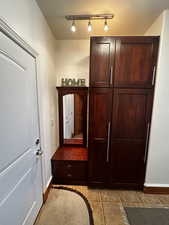 Mudroom with rail lighting and light tile patterned floors