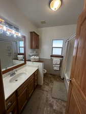 Full bathroom featuring tile patterned floors, toilet, shower / tub combo, and vanity