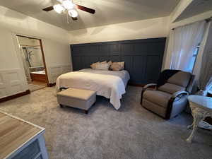 Bedroom with connected bathroom, ceiling fan, and carpet flooring