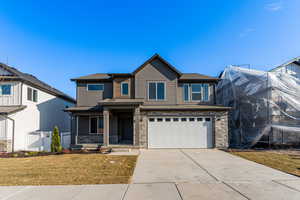 View of front of home with a garage and a front lawn