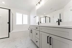 Bathroom featuring vanity and shower with separate bathtub