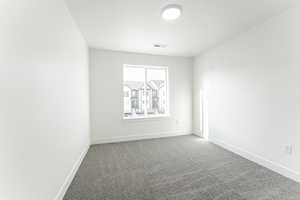 Carpeted spare room featuring a textured ceiling