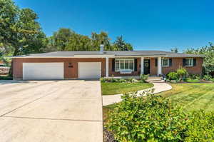 Ranch-style house featuring a garage and a front lawn