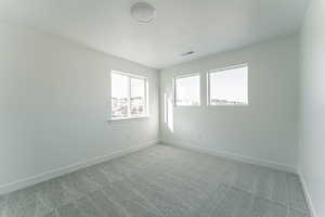 Carpeted spare room featuring a textured ceiling