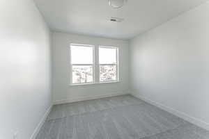 Spare room featuring light carpet and a textured ceiling