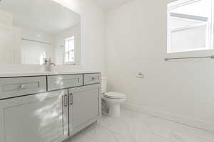 Bathroom with a shower, vanity, and toilet