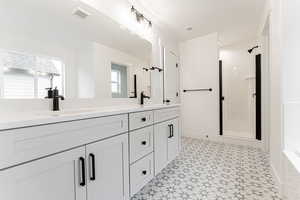 Bathroom with vanity and a shower with shower door