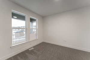 Unfurnished room featuring carpet floors and a healthy amount of sunlight