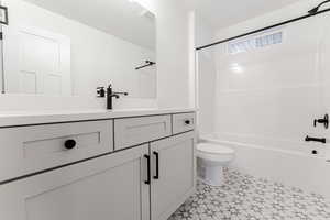 Full bathroom featuring toilet, vanity, and tub / shower combination