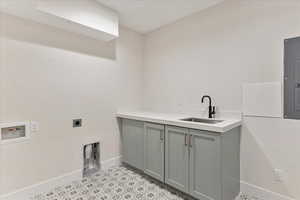 Washroom with hookup for a washing machine, sink, cabinets, light tile patterned floors, and electric dryer hookup