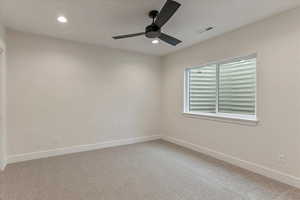 Carpeted spare room with ceiling fan