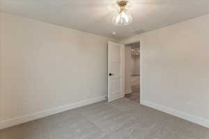 Unfurnished room featuring light carpet and a textured ceiling