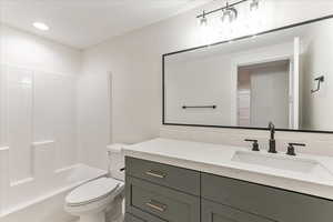 Full bathroom with vanity, shower / bath combination, and toilet