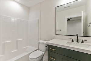 Full bathroom featuring vanity, washtub / shower combination, ceiling fan, and toilet