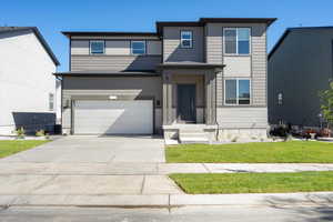 View of front facade featuring a garage, central AC, and a front yard