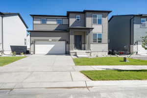 View of front of property with a front yard and a garage