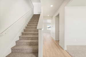 Stairway featuring hardwood / wood-style floors