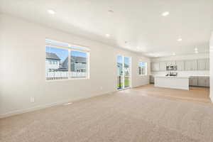 Unfurnished living room featuring light hardwood / wood-style flooring and plenty of natural light