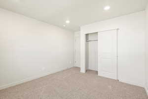 Unfurnished bedroom featuring carpet flooring and a closet