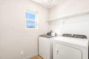 Washroom featuring light hardwood / wood-style floors and separate washer and dryer