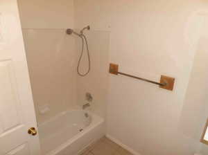 Bathroom with shower / washtub combination and tile patterned floors