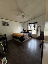 Bedroom featuring dark wood-type flooring, a textured ceiling, and ceiling fan